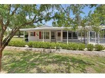 Charming single-story home featuring a screened-in porch and well-manicured landscaping at 25305 Mardon Cir, Paisley, FL 32767