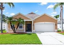 Charming single-story home featuring a two-car garage and tropical landscaping at 452 Casa Marina Pl, Sanford, FL 32771