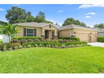 Inviting single-story home featuring lush landscaping, a well-manicured lawn, and a convenient three-car garage at 508 Morgan Wood Dr, Deland, FL 32724