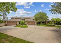 A well-maintained property with lush landscaping and a large driveway leading to multiple garages at 510 Sandy Bluff Trl, Deland, FL 32724