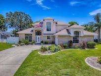 Charming two-story home boasts a manicured lawn, mature landscaping, and an inviting entrance with brick accents at 5936 Boggs Ford Rd, Port Orange, FL 32127
