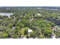 An aerial view of a property surrounded by mature trees and landscaping near a lake and adjacent neighborhood at 626 Cannon St, Daytona Beach, FL 32114