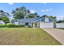 Charming single-Gathering home featuring a well-manicured lawn and attached two-car garage, blending comfort and convenience at 2237 Clearwater Dr, Deltona, FL 32738