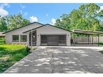 Well-maintained, one-story home featuring a two-car garage and covered parking with mature trees in a quiet neighborhood at 28432 Tammi Dr, Tavares, FL 32778