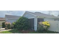 Home's exterior showcases lush landscaping and screened porch for outdoor enjoyment at 3339 Croton Ave, Deltona, FL 32738