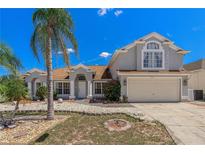 Charming home showcasing a well-maintained front yard, a two-car garage, and beautiful landscaping at 437 Grand Reserve Dr, Davenport, FL 33837