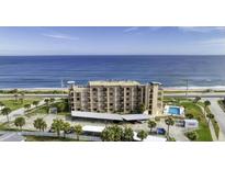 Stunning aerial view of oceanfront condo building with a pool, parking, and beautiful ocean views at 2390 Ocean Shore Blvd # 1040, Ormond Beach, FL 32176