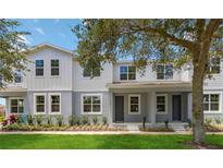 Two-story townhome with gray and white exterior, landscaping, and front porch at 6915 Five Oaks Dr, St Cloud, FL 34773