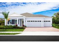 One-story home with gray exterior, two-car garage, and landscaping at 3036 Robles Rd, Clermont, FL 34711