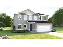 Two-story house with gray siding, two-car garage, and landscaping at 7427 Sw 108Th St, Ocala, FL 34476