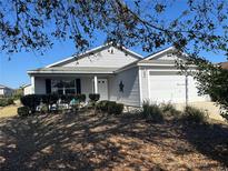 Charming one-story home with a well-maintained yard, featuring a 2-car garage and cozy front porch at 2595 Edenville Path, The Villages, FL 32162