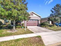 Charming one-story home with a two-car garage, lovely landscaping, and inviting curb appeal at 22004 Belgian Ct, Mount Dora, FL 32757