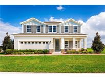 Two-story house with gray siding, stone accents, and a three-car garage at 437 Hammock Oaks Blvd, Lady Lake, FL 32159