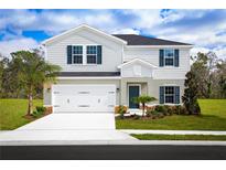 Charming two-story home features a well-maintained lawn, attached two car garage, and eye-catching blue shutters at 1554 Landon Ln, Haines City, FL 33844