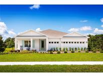 Charming single-story home with a manicured front lawn, beautiful landscaping, and a spacious three car garage at 1564 Covey Rise Ter, Winter Haven, FL 33884