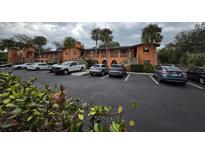 Condominium building with a parking lot in front at 722 E Michigan St # 145, Orlando, FL 32806