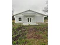 Charming single-story home featuring a metal roof, double doors, and light gray siding at 36702 Calhoun Rd, Eustis, FL 32736