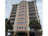 Beautiful multi-story building with balconies, decorative insets, and palm trees at 1425 Ocean Shore Blvd # 402, Ormond Beach, FL 32176