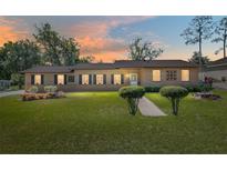 Charming single-story home with well-manicured lawn and neatly trimmed shrubs under a vibrant sunset sky at 3200 Se 34Th St, Ocala, FL 34471