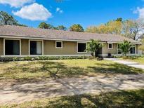 Charming single-story home featuring a large front yard with mature landscaping and beautiful trees at 4931 Tropicana Dr, Indian Lake Estates, FL 33855
