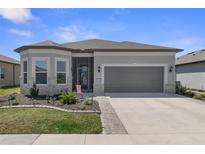 Charming one-story home featuring stone accents, manicured landscaping, and a gray two-car garage at 8534 Sw 59Th Lane Rd, Ocala, FL 34481