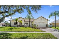 Inviting single-story home with a well-manicured lawn, a tile roof, and a two-car garage at 3601 Weatherfield Dr, Kissimmee, FL 34746