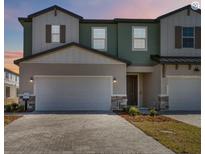Charming two-story townhome featuring a two-car garage and neutral color palette at 1104 Desert Candle Dr, Ocoee, FL 34761