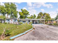 Charming single-story home with lush lawn and a large covered carport, perfect for outdoor living and entertaining at 3423 Publix Rd, Lakeland, FL 33810