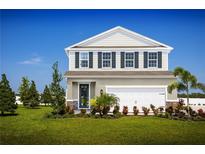 Charming two-story home featuring a manicured lawn and attached two-car garage at 5031 Bear Lake Loop, Deland, FL 32724