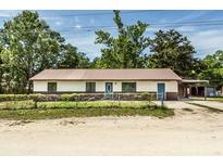 Cozy one-story home featuring a charming front yard, metal roof and rustic accents at 910 Nw 56Th Ave, Ocala, FL 34482