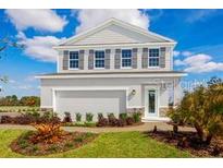 Charming two-story home featuring a clean gray exterior, complemented by dark shutters and a well-manicured front yard at 1310 Whispering Ln, Minneola, FL 34715
