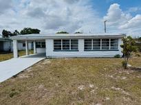 Charming single-story home featuring a metal roof, carport, and multiple windows at 232 Thomas Ave, Frostproof, FL 33843