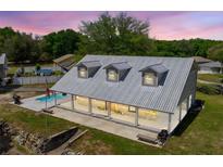 Charming home featuring a metal roof, inviting front porch, and a refreshing swimming pool on a spacious lot at 13700 Sw 108Th Ln, Dunnellon, FL 34432