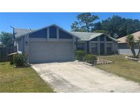 Charming single-Gathering home featuring a two-car garage, landscaped yard and an inviting curb appeal at 613 Bayport Dr, Kissimmee, FL 34758