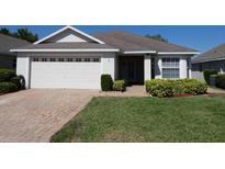 Charming one-story home with well-maintained landscaping, a brick driveway, and a two-car garage at 3806 Osprey Pointe Cir, Winter Haven, FL 33884