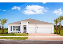 A beautiful single-story home showcasing a well-manicured lawn, brick driveway, and two-car garage at 11037 Nellie Crossing Cir, Clermont, FL 34711