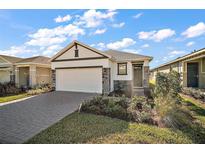 Charming single-story home featuring a landscaped yard, brick accents, and a two-car garage at 4106 Nw 44 Cir, Ocala, FL 34482