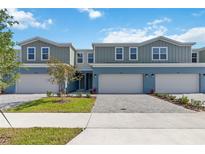 Well-manicured townhomes with two-car garages, manicured landscaping, and paver driveways at 5240 Luisa Ct, St Cloud, FL 34771