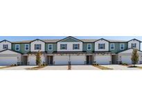 View of the exterior of the townhomes featuring a garage, lawn, and neutral color palette at 1096 Desert Candle Dr, Ocoee, FL 34761