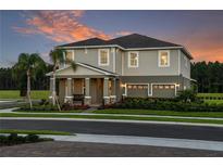 Beautiful two-story home with a spacious front porch and attached two-car garage at 136 Venetian Palms Blvd, New Smyrna Beach, FL 32168