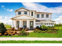 Beautiful two-story home with a manicured lawn and welcoming front porch at 3210 Tiger Palm Way, New Smyrna Beach, FL 32168