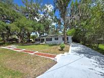 Charming single-story home with mature trees, landscaped yard, and long driveway at 2827 Se 2Nd St, Ocala, FL 34471