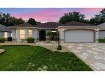 Beautiful home featuring a well-manicured lawn and an elegant stone-paved driveway at 1424 Figueroa St, The Villages, FL 32162