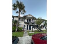 Two-story apartment building with a palm tree in the foreground and a parking lot visible at 3651 N Goldenrod E Rd # 102, Winter Park, FL 32792