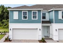 Charming two-story home with a white garage door and light blue siding and white trim at 1145 Red Buckeye Ct, Deland, FL 32720