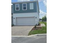 Charming two-story townhouse with a paved driveway and attached two-car garage at 1145 Red Buckeye Ct, Deland, FL 32720