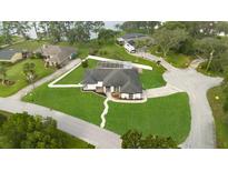 Expansive lakefront property features lush lawn, fenced yard, and screened lanai, offering privacy and serene outdoor living at 1148 Rosetta Dr, Deltona, FL 32725