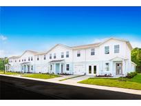Modern townhome exterior featuring individual garages, private entrances, and landscaped front yards at 1203 Port Blue Way, Lady Lake, FL 32159