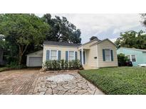 Charming single-story home featuring a stone pathway, well-kept landscaping, and an attached garage at 423 E Kaley St, Orlando, FL 32806