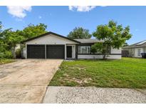 Charming single-story home boasts a well-maintained lawn and a convenient two-car garage at 7289 Lake Floy Cir, Orlando, FL 32819